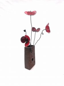 cuatro amapolas de forja sujetas a un metal que hace de jarrón. Amapola jarrón metal