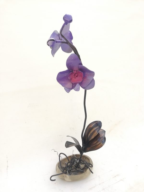 Un orquídea morada realizada en forja sobre una superficie de cerámica