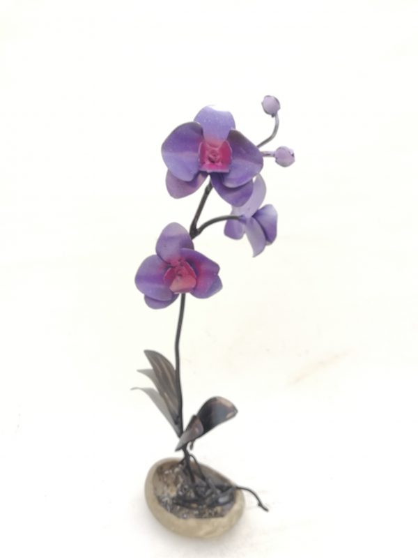 Un orquídea morada realizada en forja sobre una superficie de cerámica