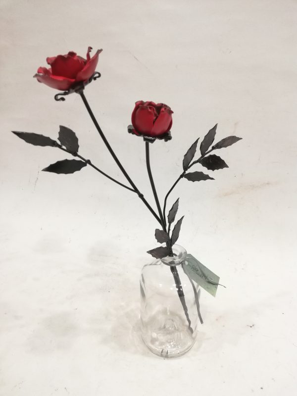 dos rosas de forja en un recipiente de cristal