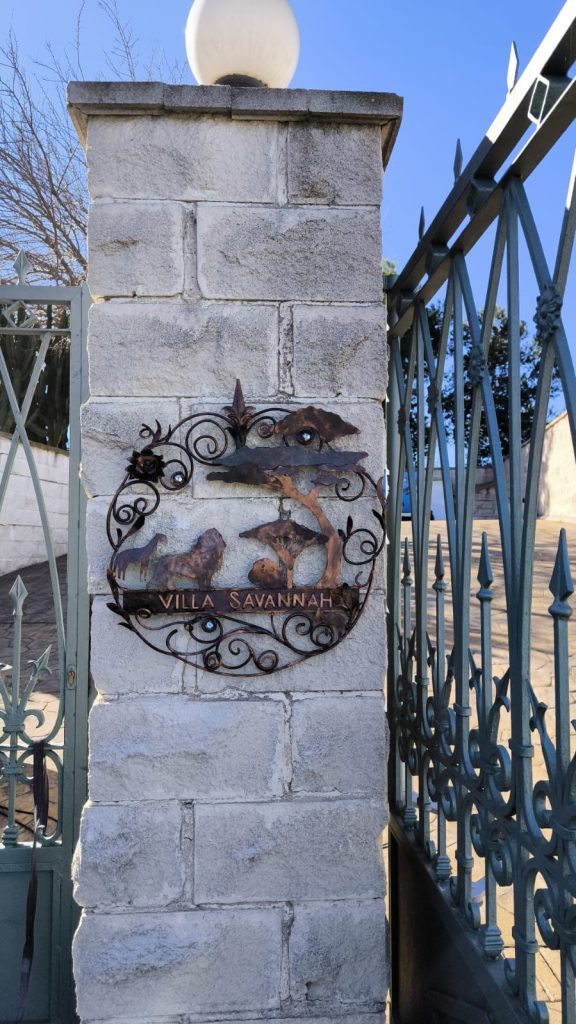 Cartel de metal con figuras de animal sobre fachada de piedra